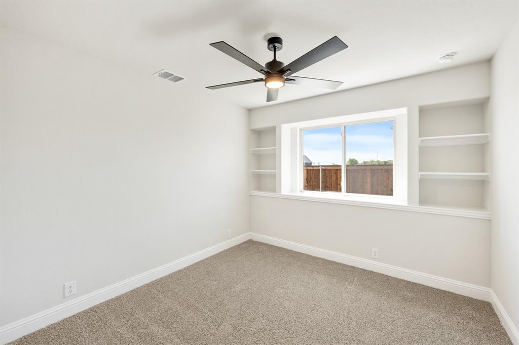 11916 Serval Street Godley, TX 76044 - Photo 21 of 35 an empty room with a window and a fan