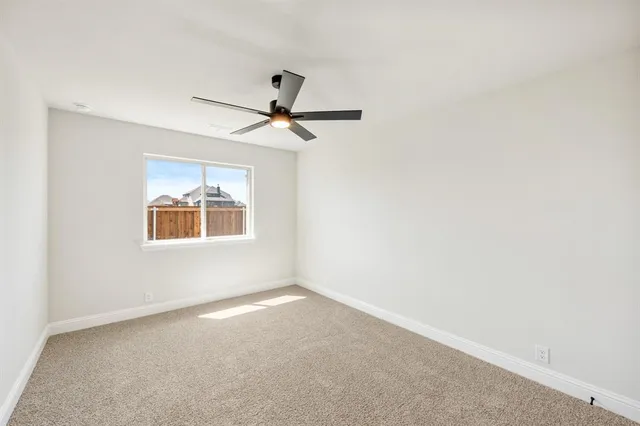 an empty room with a window and a fan