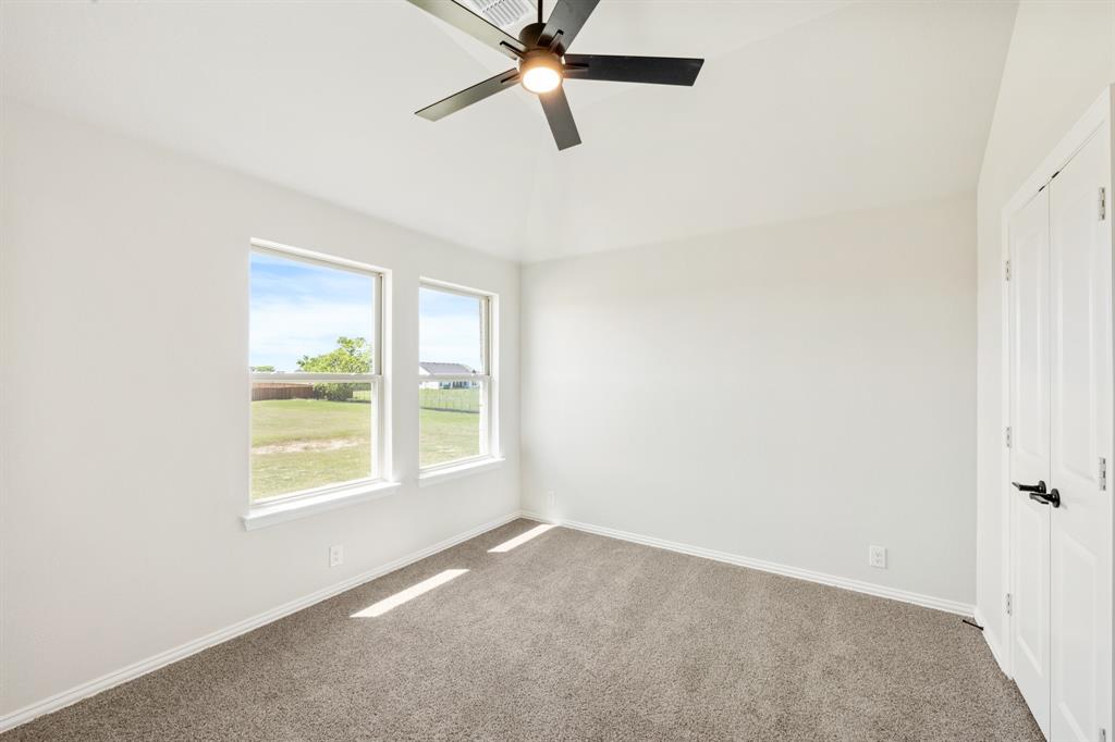 11916 Serval Street Godley, TX 76044 - Photo 28 of 35 an empty room with a window and a fan