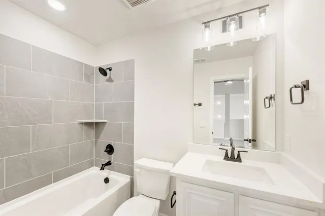 a bathroom with a sink mirror toilet and bathtub