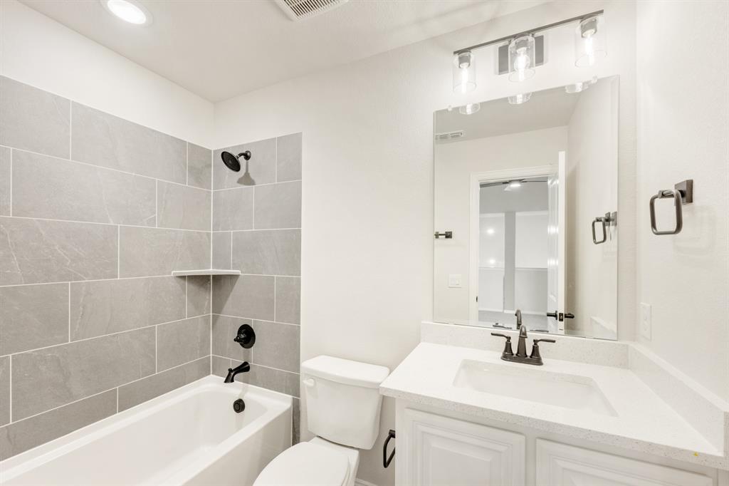 11916 Serval Street Godley, TX 76044 - Photo 29 of 35 a bathroom with a sink mirror toilet and bathtub