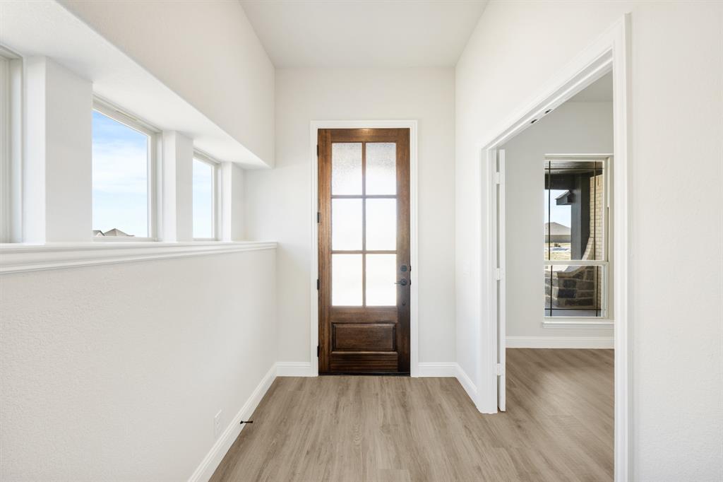 11916 Serval Street Godley, TX 76044 - Photo 5 of 35 an empty room with wooden floor and windows