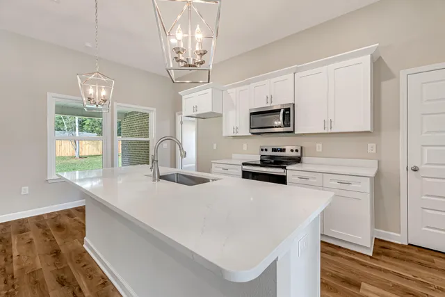 a kitchen with a sink a stove and microwave