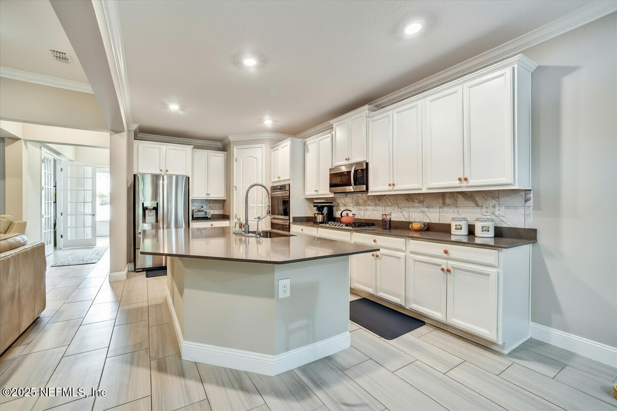 166 Oleta Way St. Augustine, FL 32095 - Photo 11 of 29 a kitchen with stainless steel appliances granite countertop a stove a sink and a refrigerator
