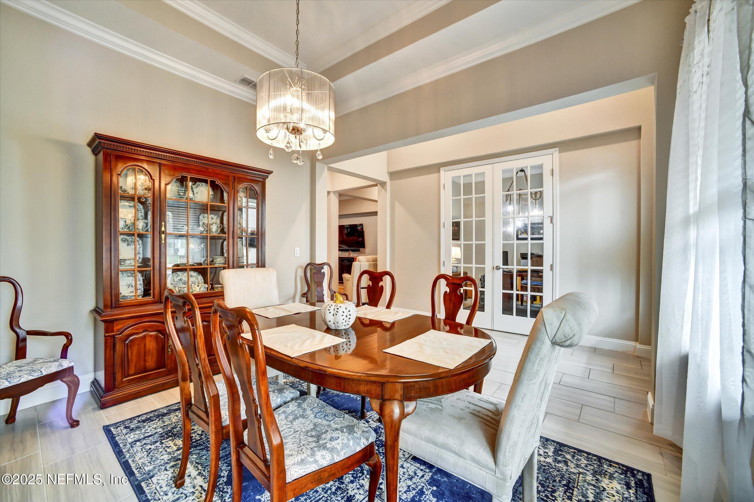 166 Oleta Way St. Augustine, FL 32095 - Photo 4 of 29 a dining room with furniture a chandelier and wooden floor