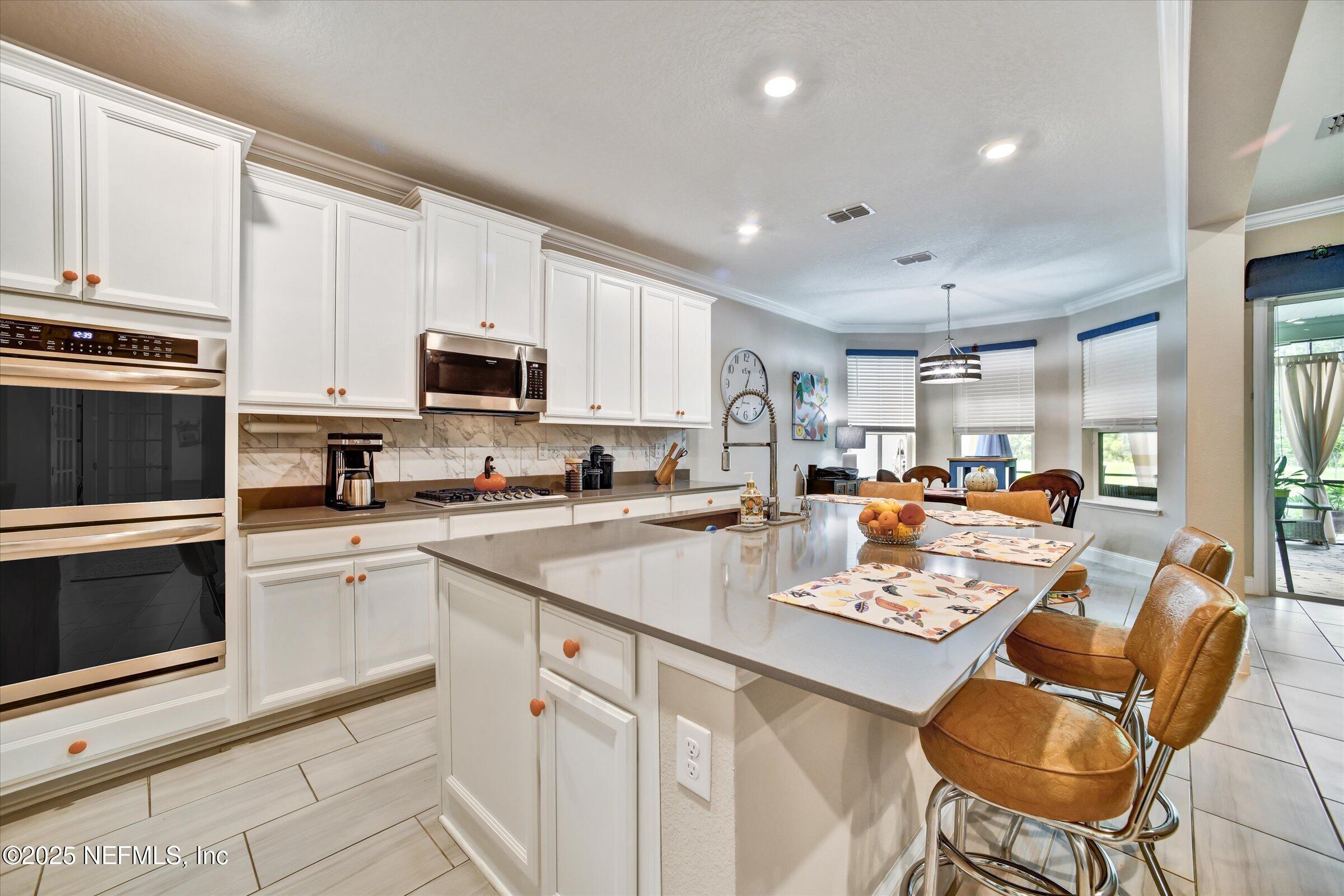 166 Oleta Way St. Augustine, FL 32095 - Photo 10 of 29 a kitchen with a sink a stove and chairs