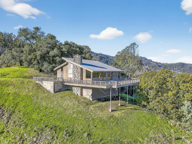a aerial view of a house with a big yard and large trees