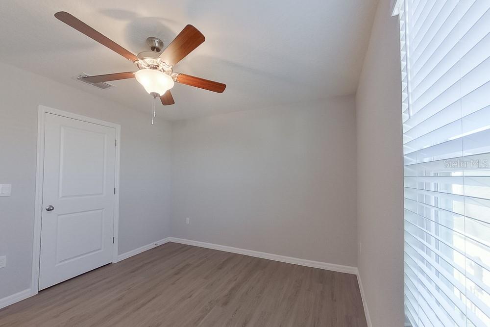 4397 Southwest 85th Lane Ocala, FL 34476 - Photo 15 of 23 an empty room with wooden floor fan and windows