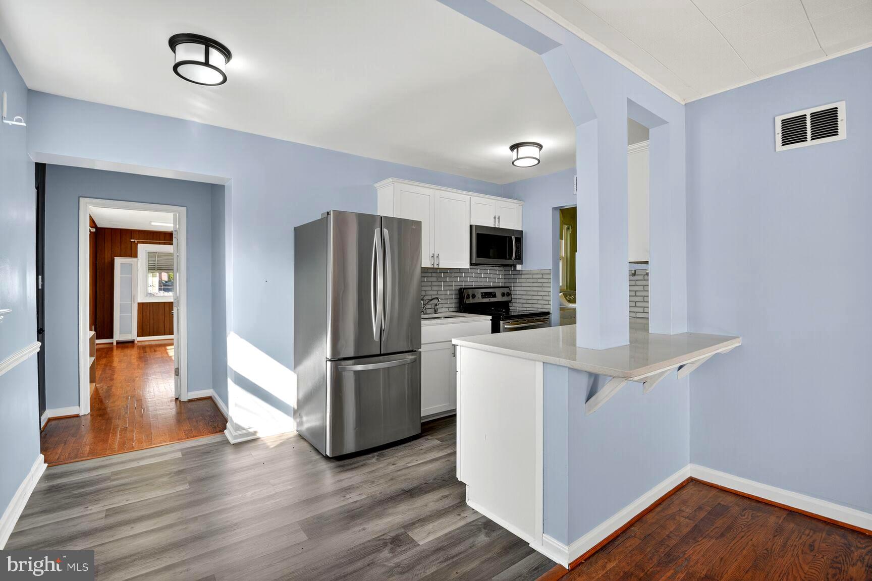 8204 17th Avenue Hyattsville, MD 20783 - Photo 12 of 36 a kitchen with a refrigerator microwave and stove