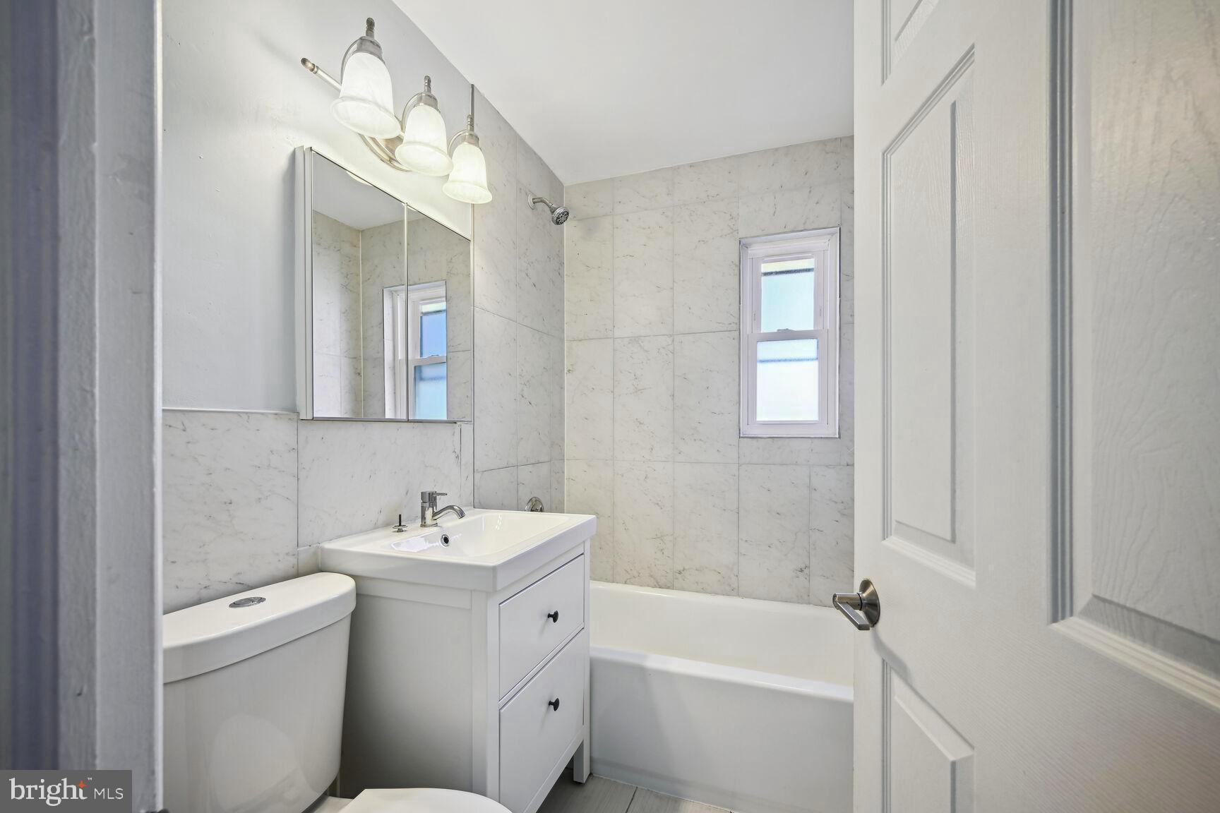 8204 17th Avenue Hyattsville, MD 20783 - Photo 28 of 36 a bathroom with a sink toilet and shower