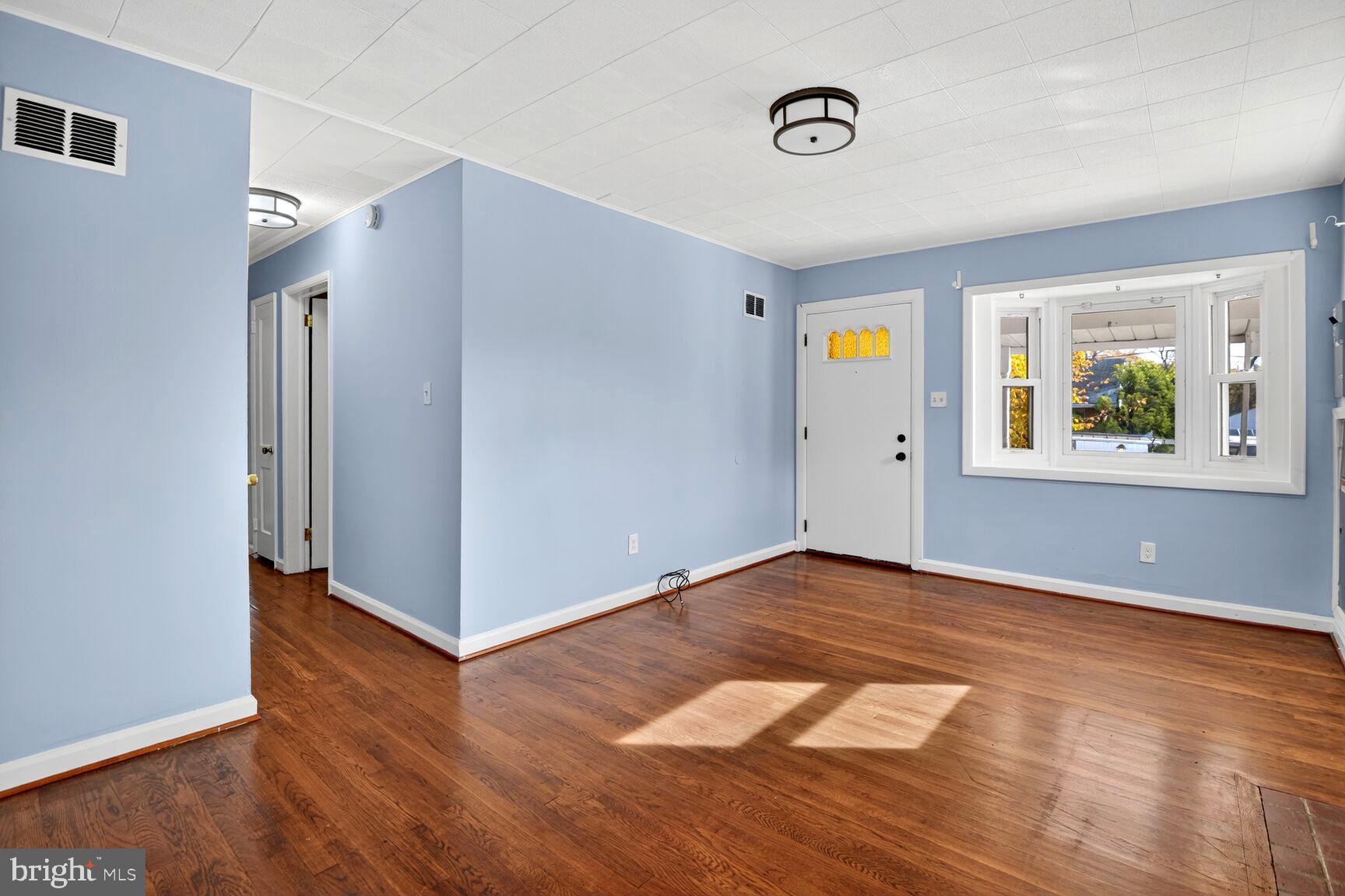 8204 17th Avenue Hyattsville, MD 20783 - Photo 3 of 36 a view of an empty room with wooden floor and windows