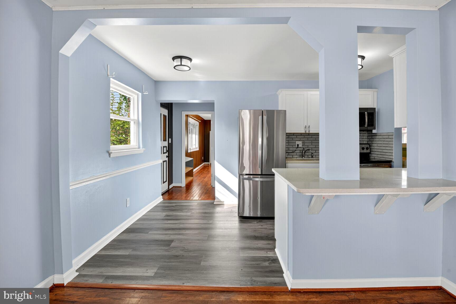 8204 17th Avenue Hyattsville, MD 20783 - Photo 7 of 36 a view of a kitchen with refrigerator and wooden floor