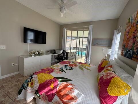 2526 Jasmine Trace Drive Kissimmee, FL 34758 - Photo 17 of 31 a bedroom with a bed and a flat screen tv
