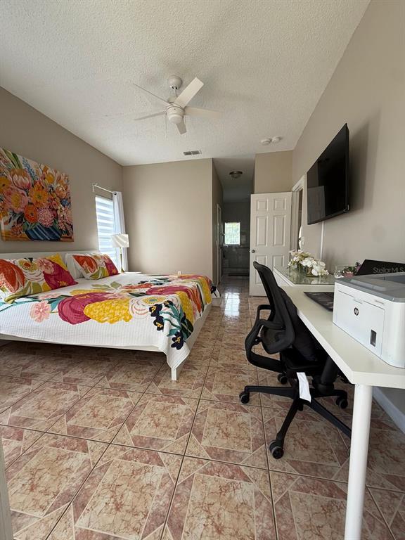 2526 Jasmine Trace Drive Kissimmee, FL 34758 - Photo 18 of 31 a bedroom with a bed and a flat screen tv