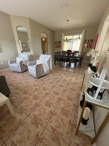 a living room with furniture and a dining table