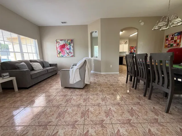 a living room with furniture a refrigerator and a window