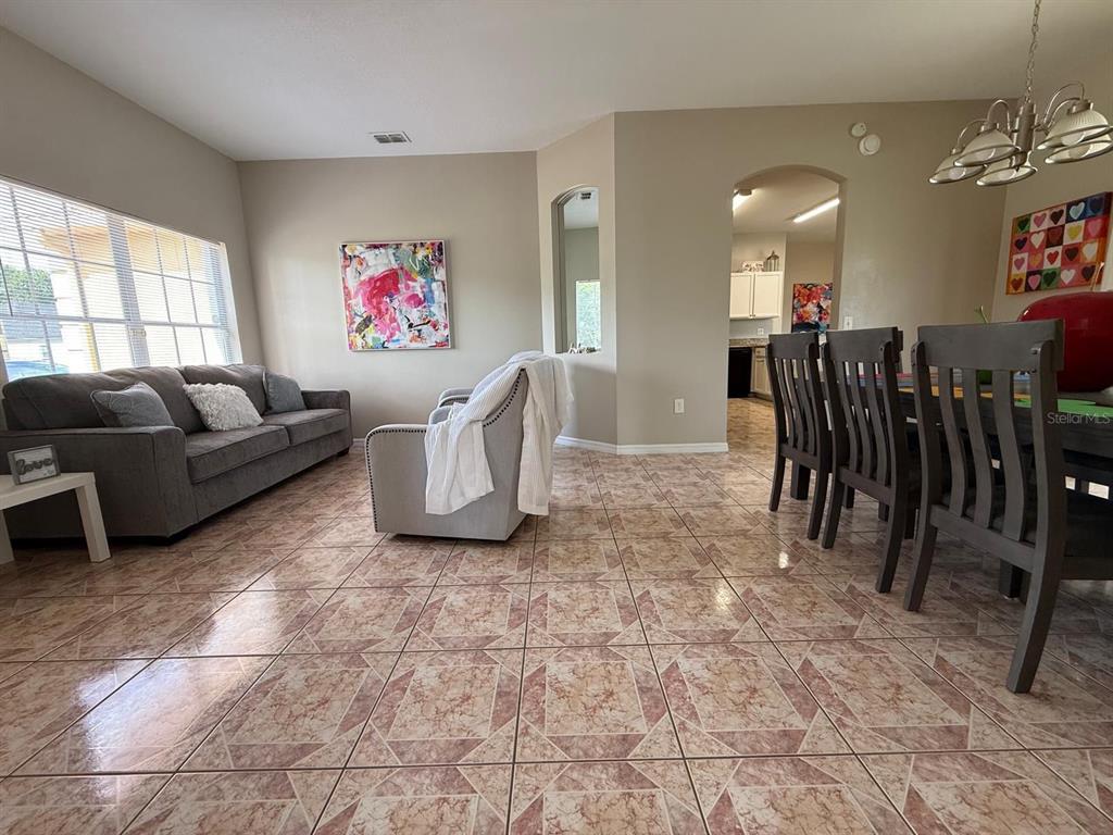 2526 Jasmine Trace Drive Kissimmee, FL 34758 - Photo 7 of 31 a living room with furniture a refrigerator and a window