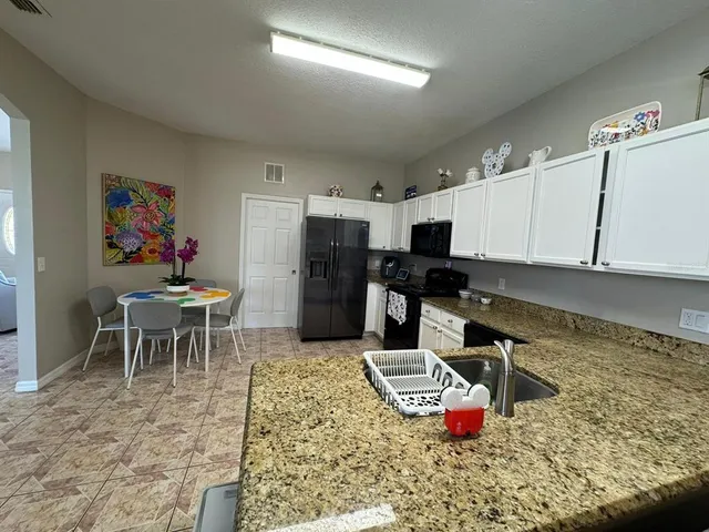 a kitchen with a refrigerator and a dining table