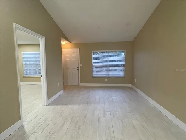 an empty room with windows and closet