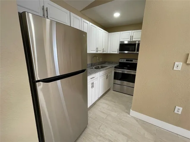 a kitchen with stainless steel appliances a refrigerator and a stove