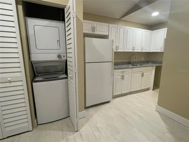 a kitchen with white cabinets and white appliances