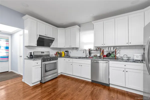 a kitchen with granite countertop white cabinets and white appliances