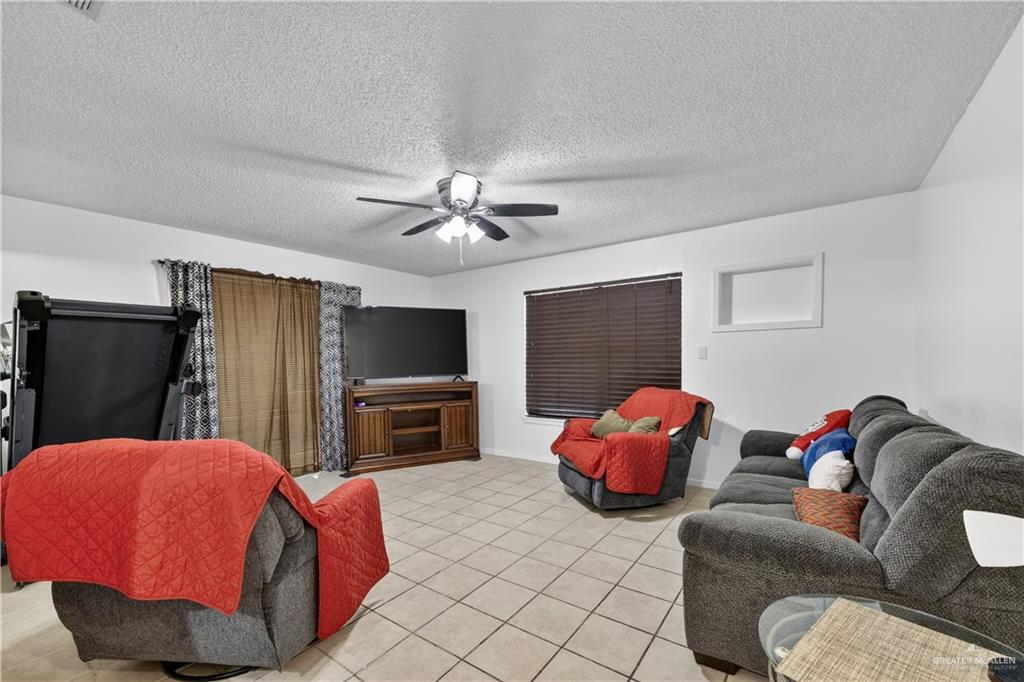 616 5th Street Weslaco, TX 78596 - Photo 26 of 33 a bedroom with furniture and a flat screen tv