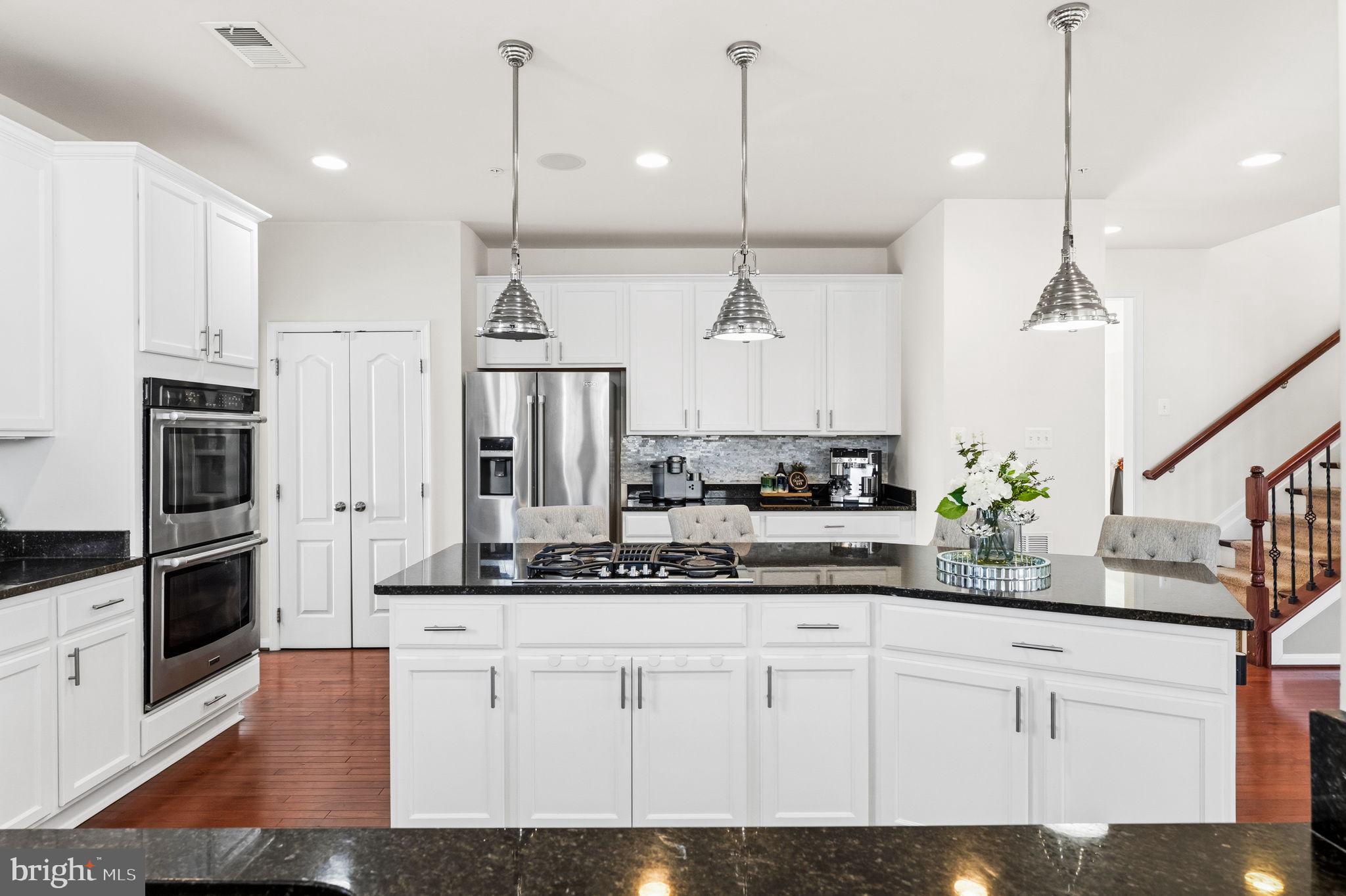 11904 Parallel Road Bowie, MD 20720 - Photo 19 of 86 a kitchen with stainless steel appliances kitchen island granite countertop a stove a refrigerator and a wooden floor