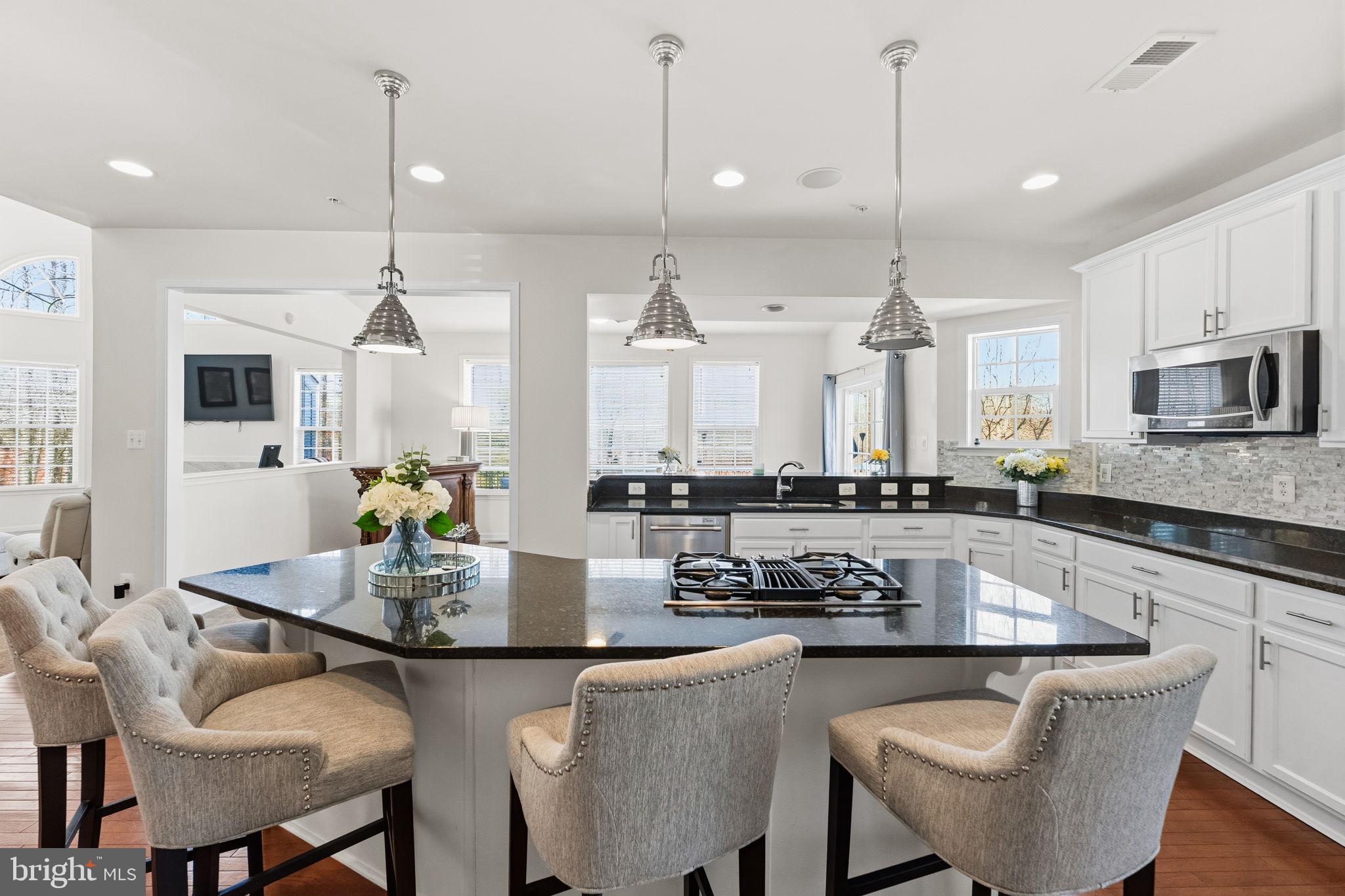 11904 Parallel Road Bowie, MD 20720 - Photo 22 of 86 a kitchen with stainless steel appliances granite countertop a stove a kitchen island a dining table and chairs