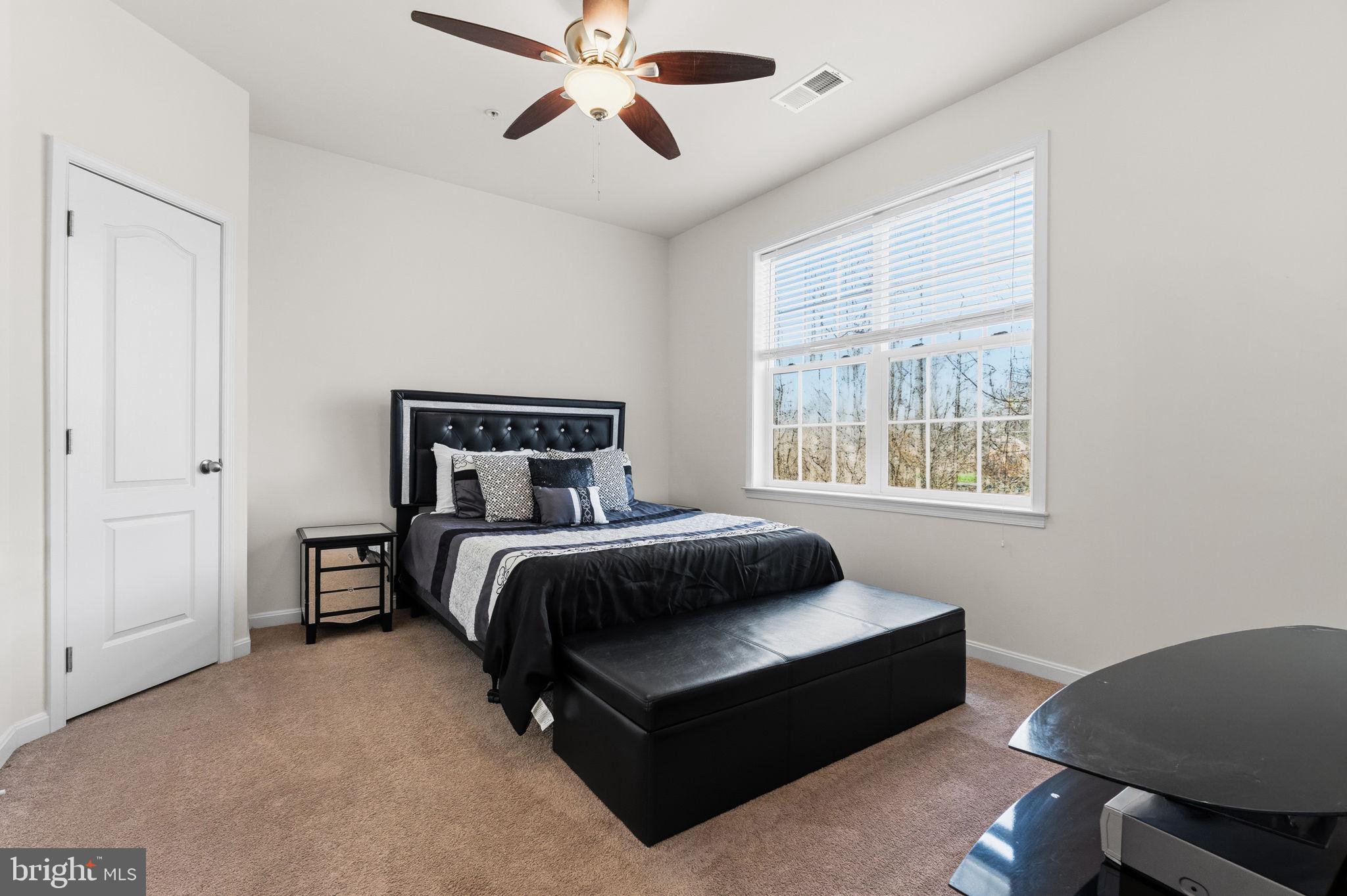 11904 Parallel Road Bowie, MD 20720 - Photo 49 of 86 a bedroom with a bed lamp and a window