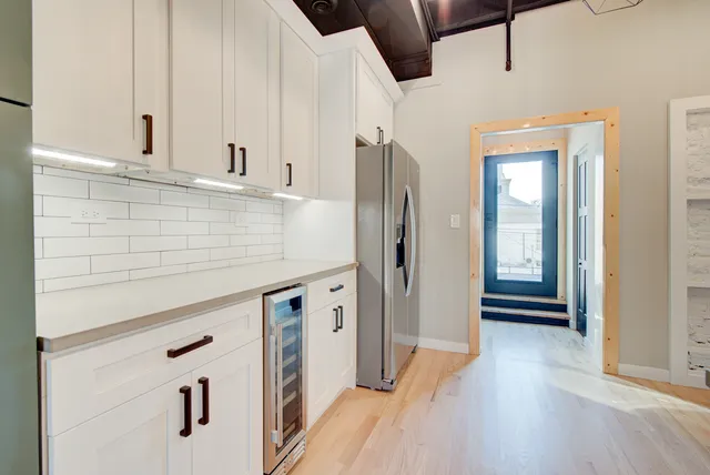 a kitchen with stainless steel appliances a stove a refrigerator a microwave and cabinets