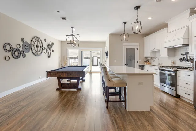 a large kitchen with cabinets a sink a stove and wooden floor