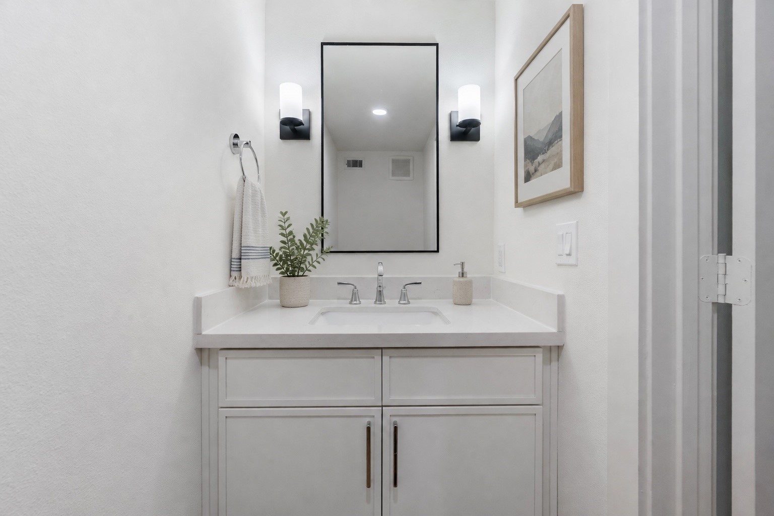 5317 Lambeth Riverside Drive Houston, TX 77091 - Photo 3 of 28 Tucked Away – The powder room is designed to ensure privacy while being conveniently
accessible. Painted vanity, quartz countertop, undermount porcelain sink, wall mounted faucet,
framed mirror flanked by elegant light sconces on both sides.