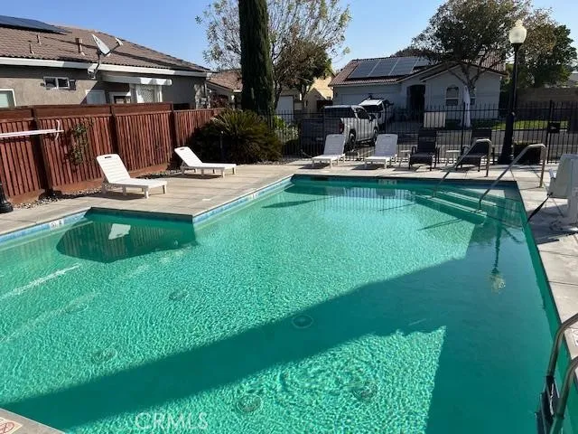 a view of a house with backyard sitting area and swimming pool