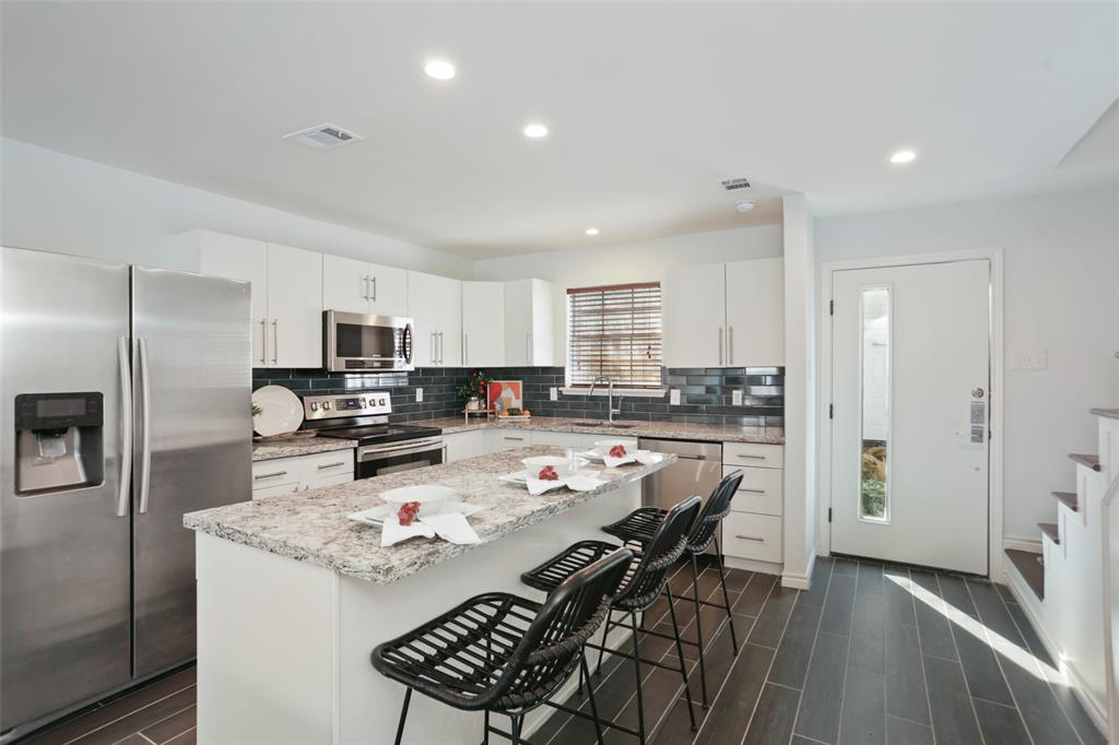 a kitchen with stainless steel appliances a refrigerator and a stove top oven