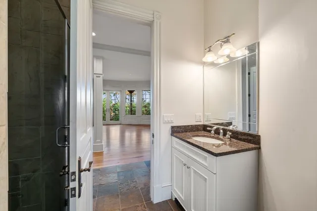 a bathroom with a granite countertop sink a mirror and a shower