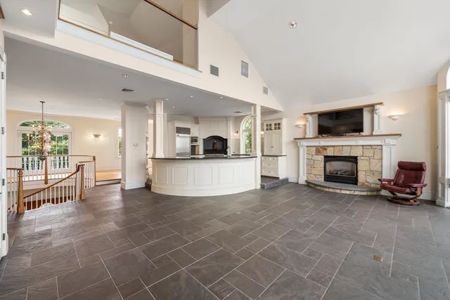 a view of a livingroom with a fireplace a kitchen and a window