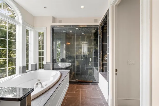 a bathroom with a granite countertop tub and a shower