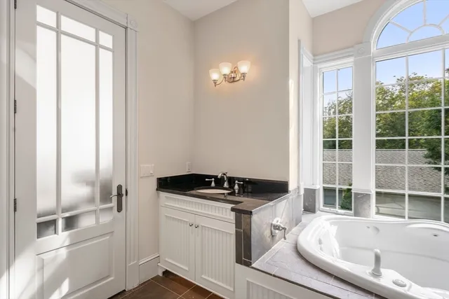 a bathroom with a tub a sink and a window