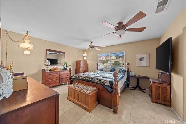 a bedroom with furniture a flat screen tv and a chandelier