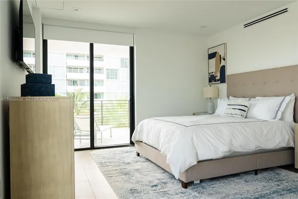 a bedroom with a bed and a large window