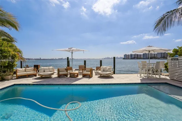 a view of a house with swimming pool and sitting area