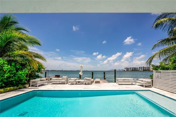 a view of swimming pool with outdoor seating and plants