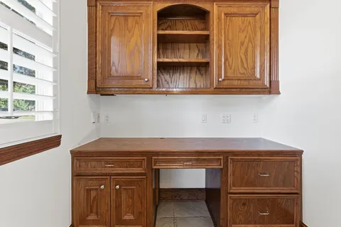 an empty room with windows closet and chandelier fan