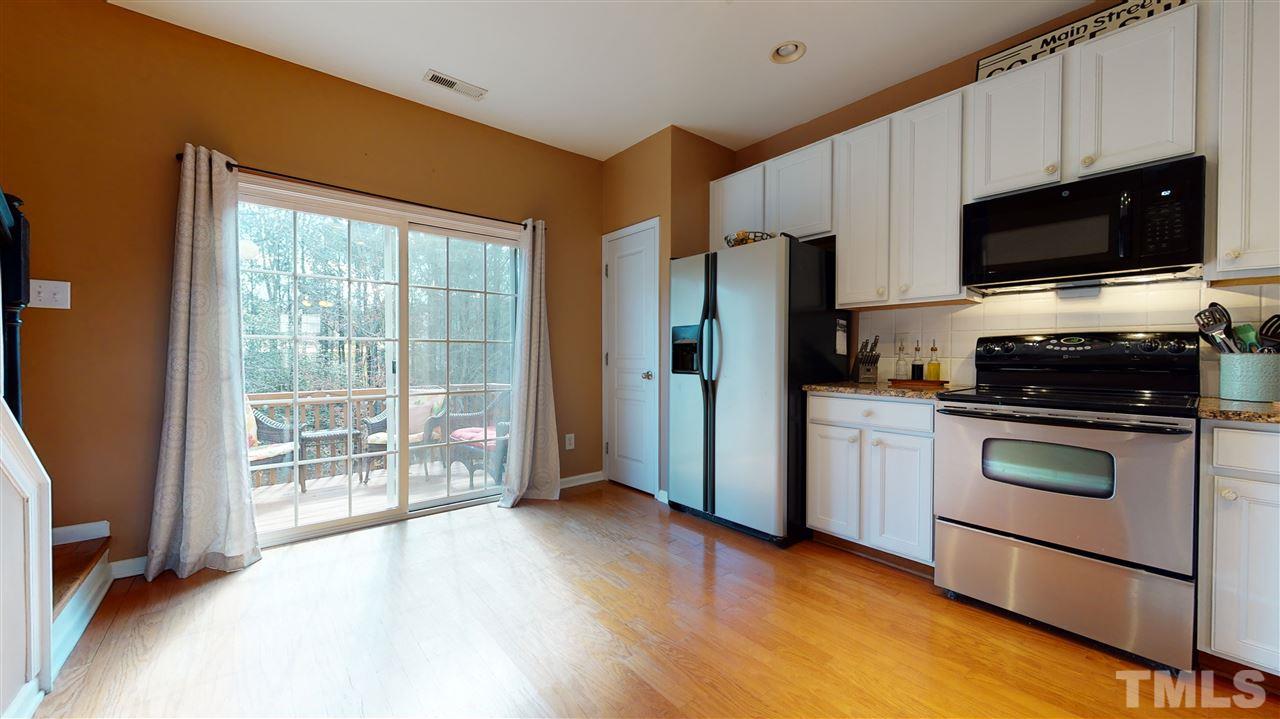 7621 Winners Edge Street Raleigh, NC 27617 - Photo 11 of 30 a kitchen with stainless steel appliances a stove a microwave and a hard wood floor