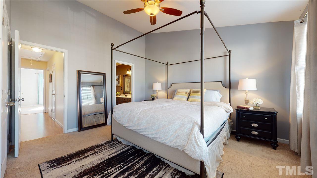 7621 Winners Edge Street Raleigh, NC 27617 - Photo 16 of 30 a bedroom with a bed and a chandelier