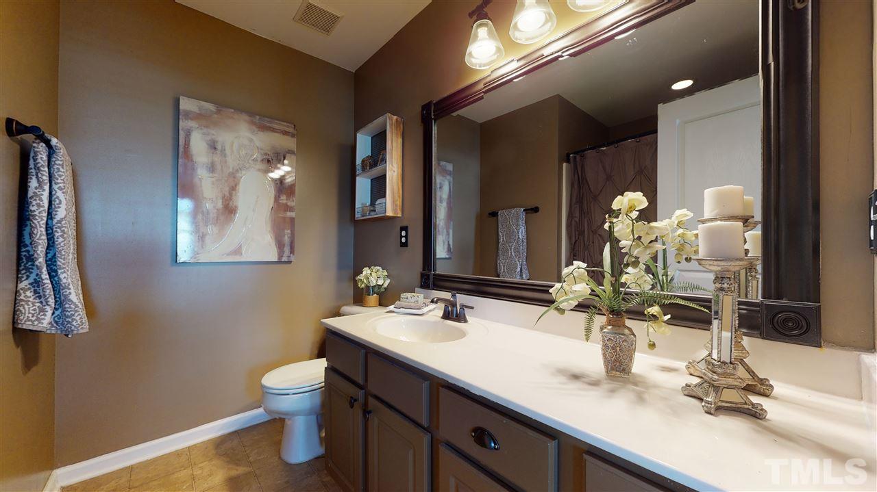 7621 Winners Edge Street Raleigh, NC 27617 - Photo 18 of 30 a bathroom with a double vanity sink and a mirror