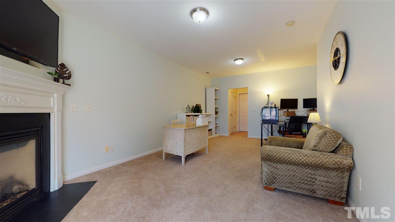 7621 Winners Edge Street Raleigh, NC 27617 - Photo 22 of 30 a living room with furniture a flat screen tv and a fireplace