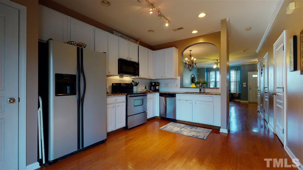 7621 Winners Edge Street Raleigh, NC 27617 - Photo 8 of 30 a kitchen with a refrigerator and a stove top oven