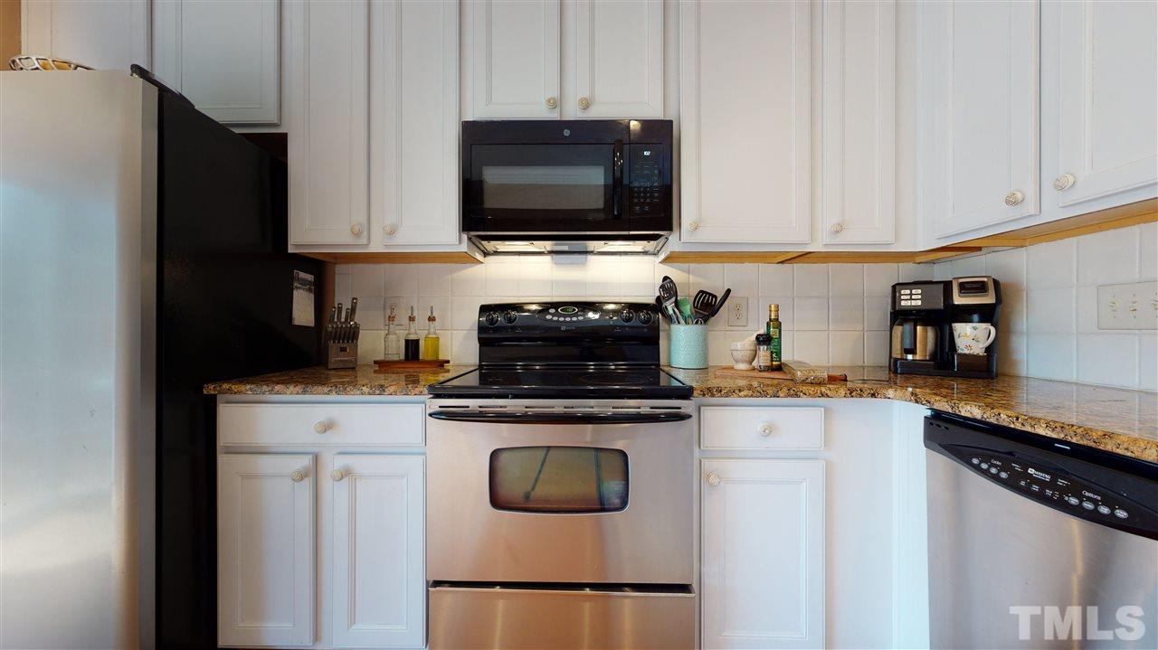 7621 Winners Edge Street Raleigh, NC 27617 - Photo 10 of 30 a kitchen with stainless steel appliances granite countertop a stove and a microwave